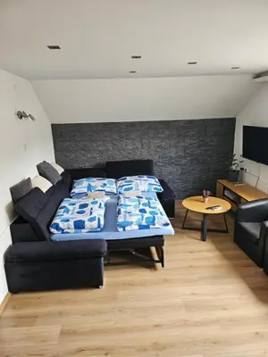 a bedroom with a bed and a couch and a table at Apartma Storžič in Preddvor