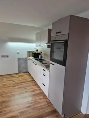 a kitchen with white cabinets and a stove top oven at Apartma Storžič in Preddvor