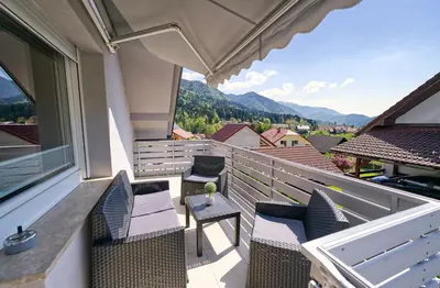 a balcony with chairs and a table and a view at Apartma Storžič in Preddvor