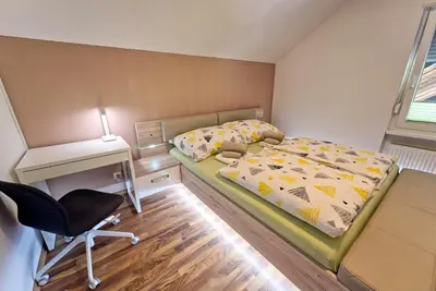 a bedroom with a bed and a desk and a chair at Apartma Storžič in Preddvor