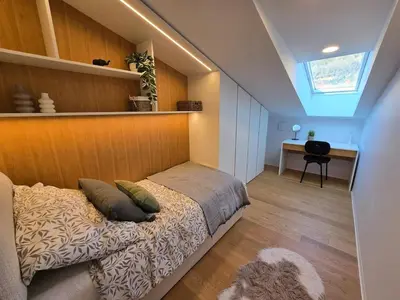 a bedroom with a bed with a wooden wall at Nova Nest from Granite Getaways in Nova Gorica