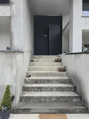 a set of concrete stairs with a black door at Nova Nest from Granite Getaways in Nova Gorica