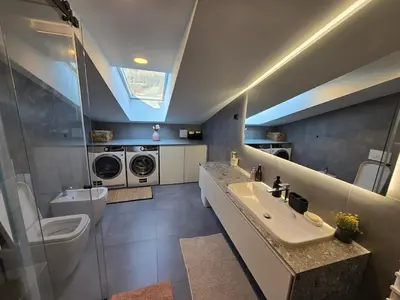 a bathroom with a sink and a washing machine at Nova Nest from Granite Getaways in Nova Gorica