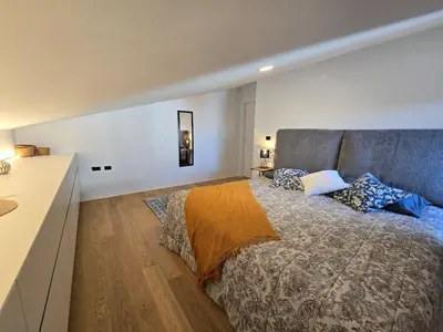 a bedroom with a large bed with a gray headboard at Nova Nest from Granite Getaways in Nova Gorica