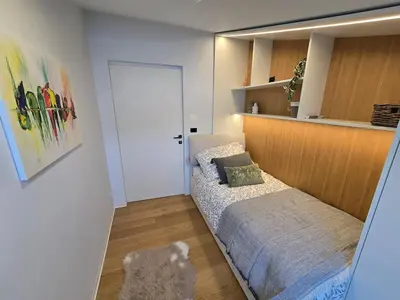 a small bedroom with a bed and a door at Nova Nest from Granite Getaways in Nova Gorica