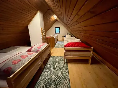 a room with four beds in a wooden room at Chalet Vogar in Bohinj