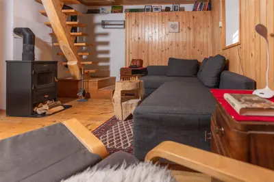 a living room with a blue couch and a stove at Chalet Vogar in Bohinj