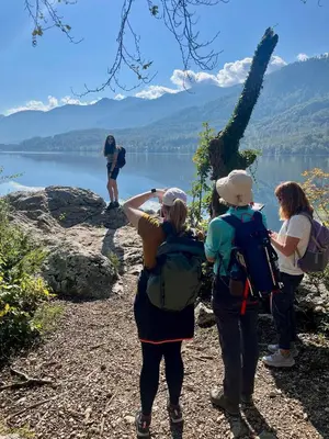 a group of people standing on a hill overlooking a lake at Chalet Vogar in Bohinj