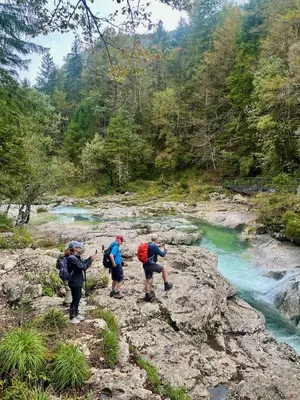 a group of three people walking along a river at Chalet Vogar in Bohinj