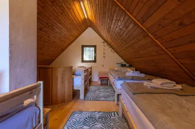 a attic room with beds and a wooden ceiling at Chalet Vogar in Bohinj
