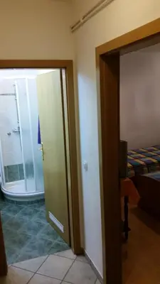a room with a door leading to a bedroom at Gostilna Stara Pošta in Pucaie