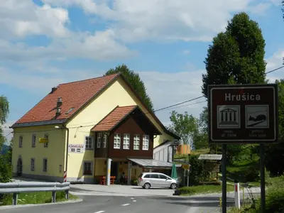 a building with a sign in front of a street at Gostilna Stara Pošta in Pucaie