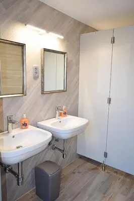 a bathroom with two sinks and a mirror at Grajski kamp - pitch your own tent in Kočevje