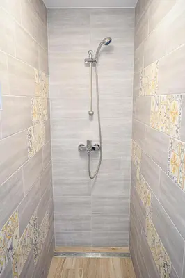 a bathroom with a shower with a tile wall at Grajski kamp - pitch your own tent in Kočevje