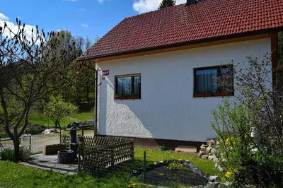 a house with two windows and a red roof at Grajski kamp - pitch your own tent in Kočevje