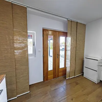 a kitchen with wooden doors and wooden floors at Stars Apartments in nature in Postojna