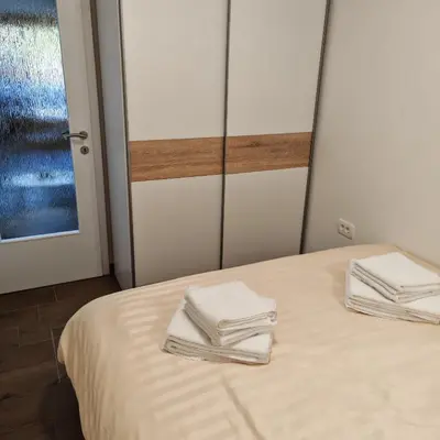 two folded towels sitting on a bed in a room at Stars Apartments in nature in Postojna