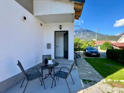 a patio with a table and chairs and a car at St Mountain Escape in Žirovnica