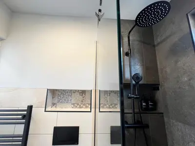 a shower with a glass door in a bathroom at St Mountain Escape in Žirovnica