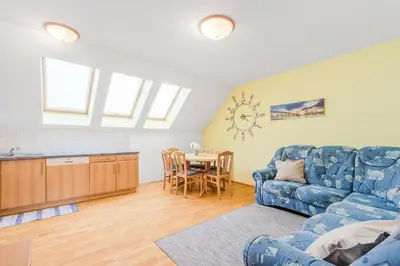 a living room with a blue couch and a table at Apartment Gaspercic in Bovec
