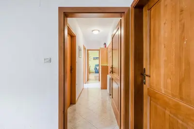 a hallway with wooden doors and a tile floor at Apartment Gaspercic in Bovec