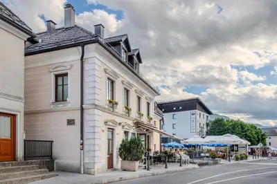 a white building on a street with tables and chairs at Apartment Gaspercic in Bovec