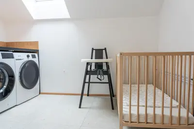 a crib and a ladder next to a washing machine at Apartment Tanja 3 Bedroom, Mountain View & Family Stay in Golnik