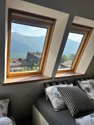 a bedroom with two windows and a bed in it at Apartma Giorgo in Bovec