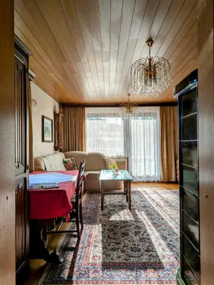 a bedroom with a bed and a couch and a chandelier at Apartma Rustika in Bled
