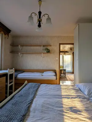 a bedroom with two beds and a desk in it at Apartma Rustika in Bled