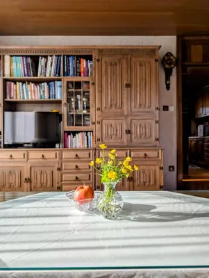 a vase of flowers and an apple on a table at Apartma Rustika in Bled