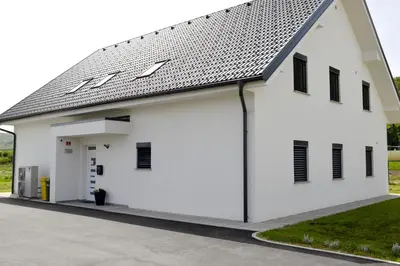 a white building with a gambrel roof at Apartmaji Baznik Čatež in Brežice