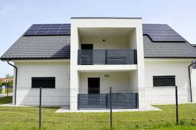 a house with solar panels on the roof at Apartmaji Baznik Čatež in Brežice