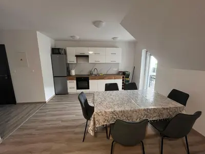 a kitchen and dining room with a table and chairs at Apartmaji Baznik Čatež in Brežice