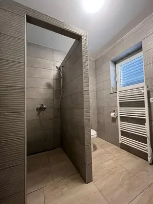 a bathroom with a shower with a toilet and a window at Apartmaji Baznik Čatež in Brežice