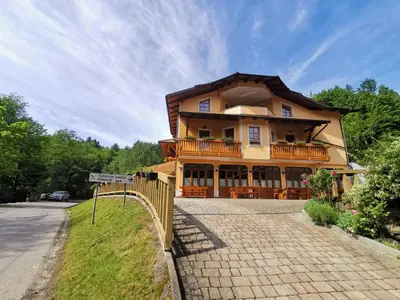 a large house with a fence in front of it at Farm Stay Peternelj in Ilirska Bistrica