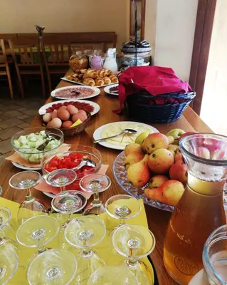 a wooden table topped with plates of food and drinks at Farm Stay Peternelj in Ilirska Bistrica