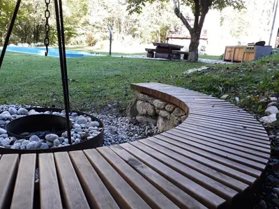 a wooden bench sitting next to a fire pit at Gorska Vila mountain villa in Soča