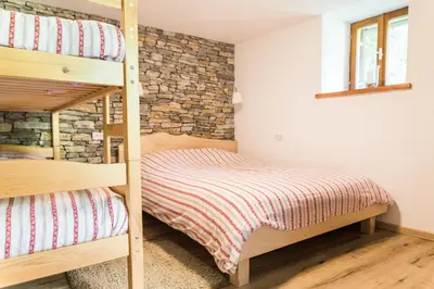 a bedroom with two bunk beds and a brick wall at Gorska Vila mountain villa in Soča