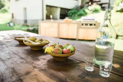a bowl of apples and a bottle of water on a wooden table at Gorska Vila mountain villa in Soča