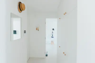 a white room with a door and a wall with stickers at Gatsby's Place in Ljubljana