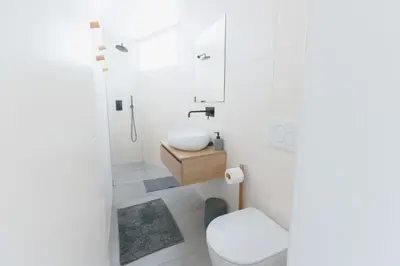 a white bathroom with a sink and a toilet at Gatsby's Place in Ljubljana