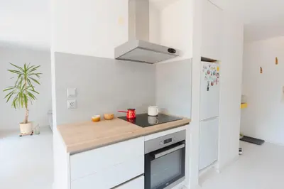 a kitchen with white cabinets and a wooden counter top at Gatsby's Place in Ljubljana