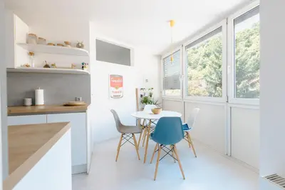 a kitchen with white counters and a table and chairs at Gatsby's Place in Ljubljana