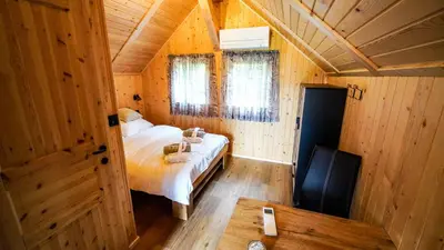 a bedroom with a bed in a wooden cabin at Glamping Avantura- a natural getaway by the Kolpa River in Kostel