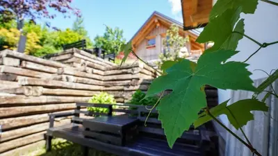 a bench in a yard with a wooden fence at Glamping Avantura- a natural getaway by the Kolpa River in Kostel