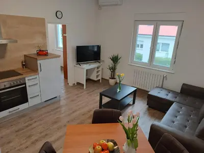 a living room with a couch and a table at Apartma Mjrka in Dobrovo