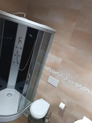 a bathroom with a toilet and a glass shower at Apartma Mjrka in Dobrovo