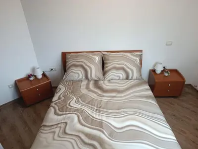 a bed with two nightstands and two tables at Apartma Mjrka in Dobrovo