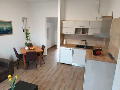 a kitchen and a living room with a table at Apartma Mjrka in Dobrovo